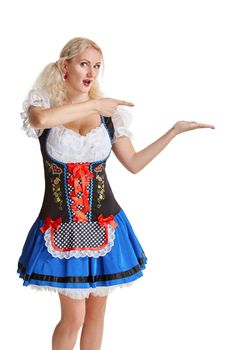 Beautiful young blond girl in dirndl drinks out of oktoberfest beer stein. Isolated on white background. pointing finger and smiling. copyspace desing concept