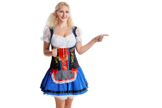 Beautiful young blond girl in dirndl drinks out of oktoberfest beer stein. Isolated white background. she holds a glass with a drink and smiling. pointing finger and smiling. copyspace desing concept