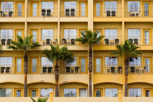 Yellow hotel with balconies.