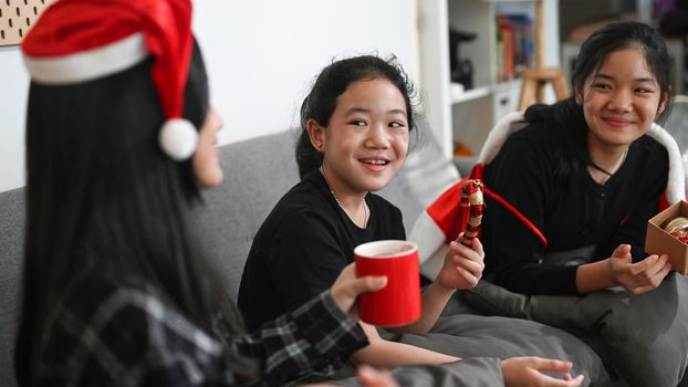 Three asian children celebrating Christmas together at home.