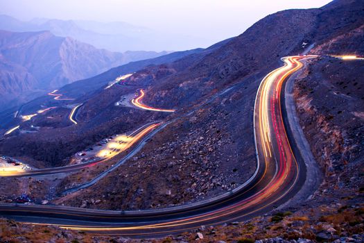 View from Jebael Jais mountain of Ras Al Khaimah emirate in the evening. United Arab Emirates, Outdoors. Light trails from the car