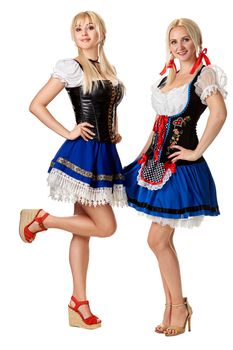 A full length portrait of two beautiful women in a traditional costume isolated on white. Oktoberfest. Beer Festival