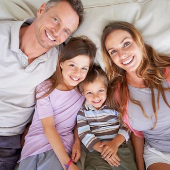 Happy times together. Portrait of a happy young family lying together on a bed