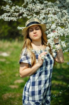 beautiful girl in a dress walking in the spring forest where the trees bloom
