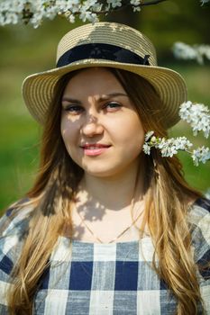 beautiful girl in a dress walking in the spring forest where the trees bloom