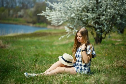 beautiful girl in a dress walking in the spring forest where the trees bloom
