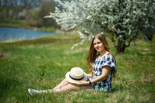 beautiful girl in a dress walking in the spring forest where the trees bloom