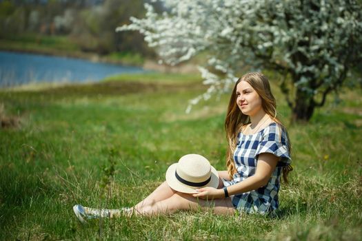 beautiful girl in a dress walking in the spring forest where the trees bloom