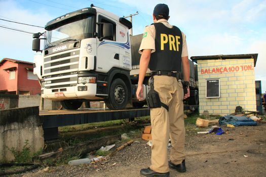 eunapolis, bahia / brazil - may 6, 2009: Federal Highway Police officer spotted during Operation on BR 101 Highway oversees overweight cargo vehicles.