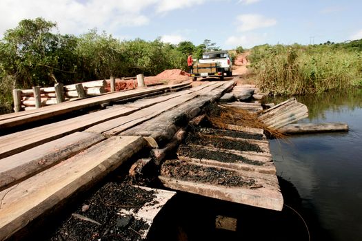 prado, bahia / brazil - july 7, 2009: vehicle is seen crossing wooden bridge over a dirt road in the rural area of the city of Prado, in southern Bahia.





