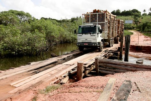 prado, bahia / brazil - july 7, 2009: vehicle is seen crossing wooden bridge over a dirt road in the rural area of the city of Prado, in southern Bahia.





