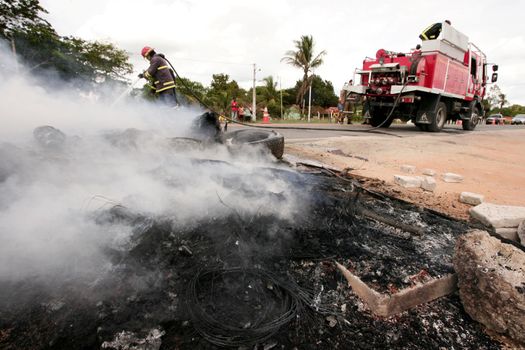 porto seguro, bahia, brazil - march 2, 2010: member of the Fire Department puts out a fire on the BR 367 highway caused by protesters during a protest in the city of Porto Seguro.