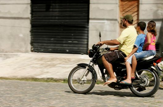 conde, bahia / brazil - june 27, 2009: three people are seen riding a motorcycle in a helmet without a helmet on a street in the municipality of Conde.