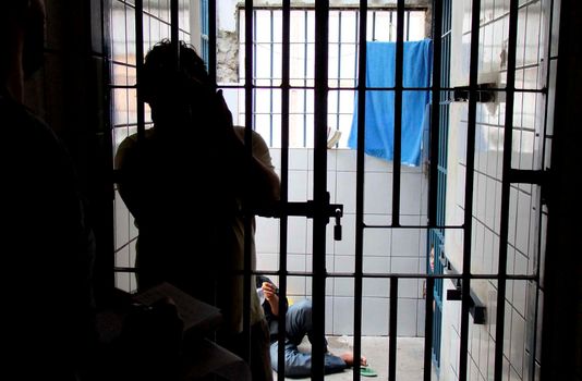 eunapolis, bahia / brazil - december 4, 2009: Convict is seen next to cell bars of Eunapolis City Police Station.



