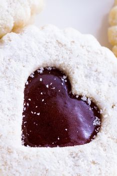 Linzer Torte cookies on white background with powdered sugar sprinkled on top.