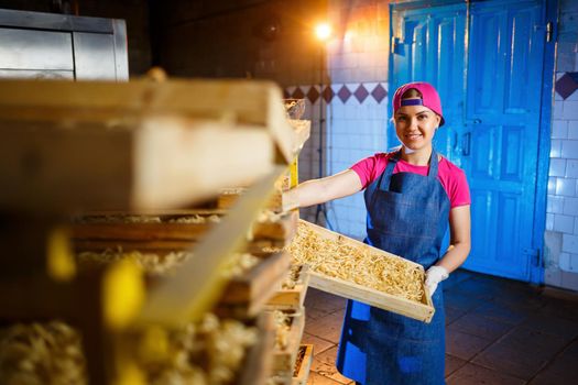 Make the noodles. Pasta factory. Spaghetti production. Raw pasta. Worker with a box of pasta. Girl works in the production of pasta