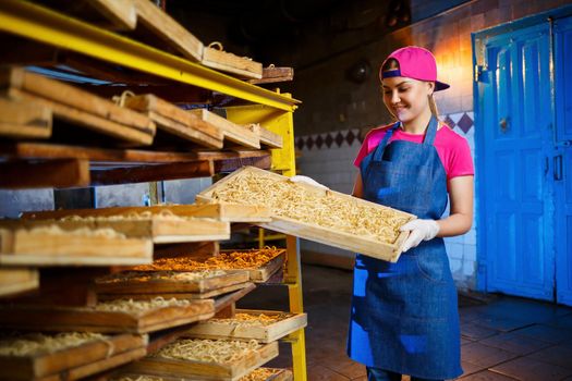 Macaroni factory. Spaghetti production. Raw pasta. Worker with a box of pasta. Girl works in the production of pasta