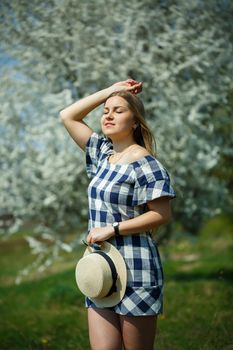 beautiful girl in a dress walking in the spring forest where the trees bloom