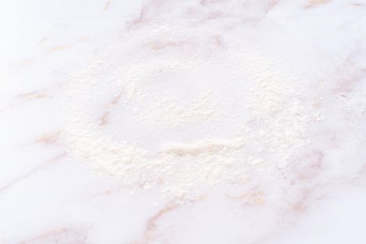 White flour sprinkled over the pink marble surface during the baking.