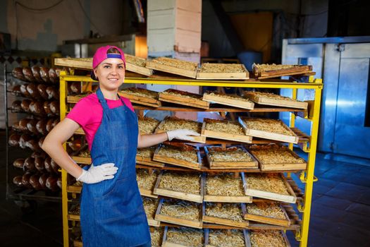 Worker with a box of pasta. The girl works on the production of spaghetti. Making noodles. Pasta factory.