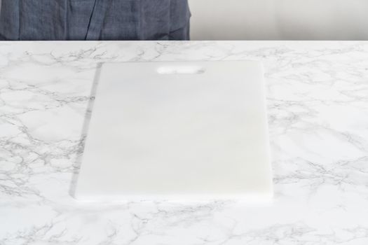 Cutting hard-boiled eggs in a shape of a loaf on a white cutting board.