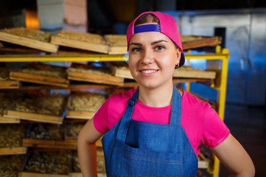 Worker with a box of pasta. The girl works on the production of spaghetti. Making noodles. Pasta factory.