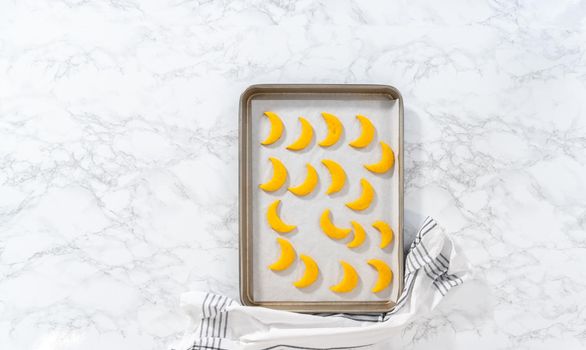 Flat lay. Lemon wedge cookies with lemon glaze. Cooling freshly baked lemon wedge cookies on a kitchen counter.