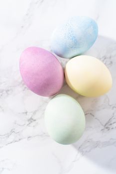 Colored hard-boiled eggs on a marble background.