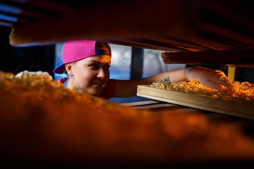 The girl works on the production of spaghetti. Making noodles. Pasta factory.