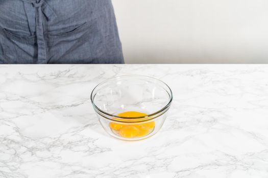 Lemon wedge cookies with lemon glaze. Mixing wet ingredients in a large glass mixing bowl to bake lemon wedge cookies.