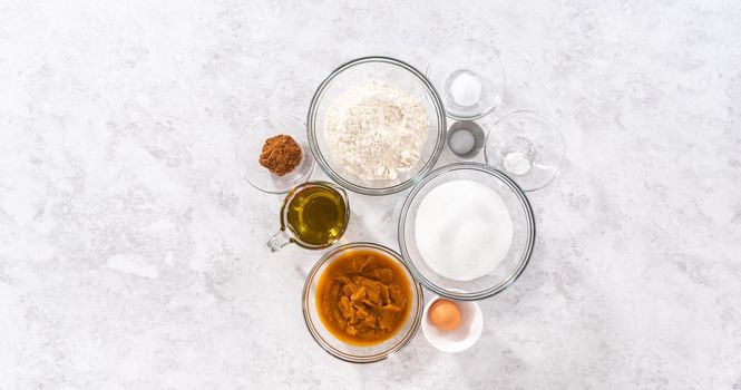Flat lay. Measured ingredients in a glass mixing bowls to bake sweet pumpkin bread.