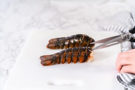 Preparing raw lobster tails to make garlic lobster tails.