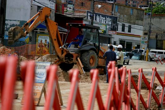 salvador, bahia, brazil - may 4, 2015: Workers use backhoe machine to excavate damaged sewer network in Salvador city.