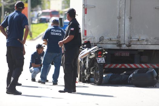 salvador, bahia / brazil - june 18, 2015: Technical Police forensic in traffic accident on Luiz Viana Avenue in Salvador. A man died while colliding a motorcycle in the bottom of a truck.