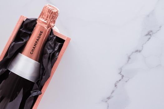 Celebration, drink and branding concept - Champagne bottle and gift box on marble, New Years, Christmas, Valentines Day or wedding holiday present and luxury product packaging for beverage brand