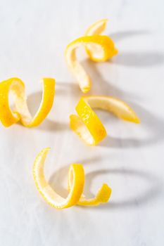 Preparing lemon swirls from the organic lemon to decorate the cocktail.