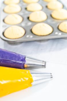 Italian buttercream batter in a piping bag with metal jumbo cupcake tips.