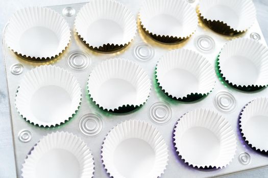 Colorful foil baking cupcake liners in cupcake pan.