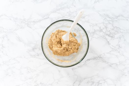 Flat lay. Mixing ingredients in a large glass mixing bowl to bake banana oatmeal muffins.