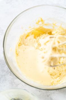 Mixing ingredients in a glass mixing bowl to bake July 4th bundt cake with chocolate stars.