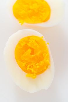 Slicing hard-boiled eggs on a white cutting board.