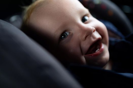 smiling baby in a carrier, traffic safety concept.