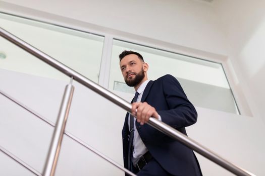businessman in a business suit climbs the stairs to the top. Career growth concept