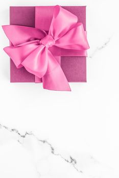 Birthday, wedding and girly branding concept - Pink gift box with silk bow on marble background, girl baby shower present and glamour fashion gift for luxury beauty brand, holiday flatlay art design