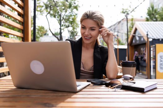 young business woman working on laptop outdoors.