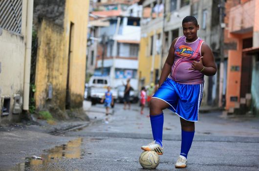salvador, bahia, brazil - september 16, 2015: young slum dweller with in the city of Salvador dreams of being a soccer player.

