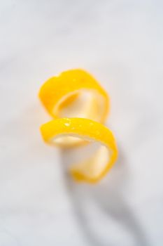 Preparing lemon swirls from the organic lemon to decorate the cocktail.