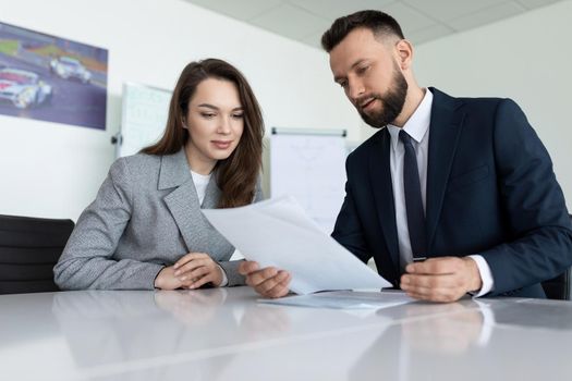 company employees studying documents for a meeting in the office.