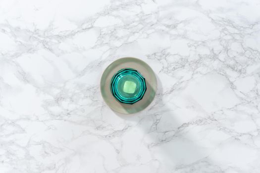 Flat lay. Softening stick of unsalted butter under a hot glass