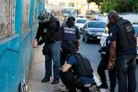 salvador, bahia, brazil - october 15, 2015: Agents from the homicide police station and experts carry out an investigation in the place where a man was murdered in the neighborhood of Sussuarana in Salvador.